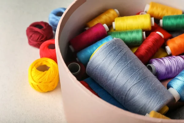 Scatola con fili per cucire a colori e uncinetto clews sul tavolo, primo piano — Foto Stock