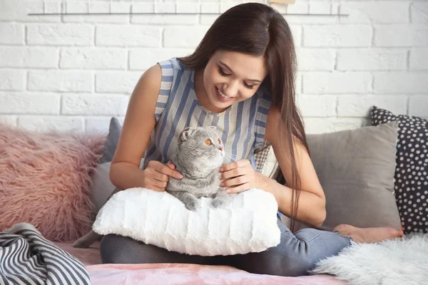 Ung kvinna med söta husdjur katt på soffan hemma — Stockfoto