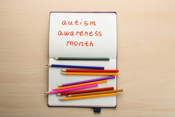 Notebook z frazą "Autism awareness month" na jasnym tle — Zdjęcie stockowe