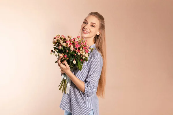 Mulher bonita com buquê de rosas no fundo de cor — Fotografia de Stock