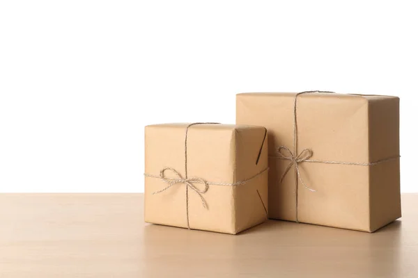 Parcel gift boxes on wooden table against white background — Stock Photo, Image