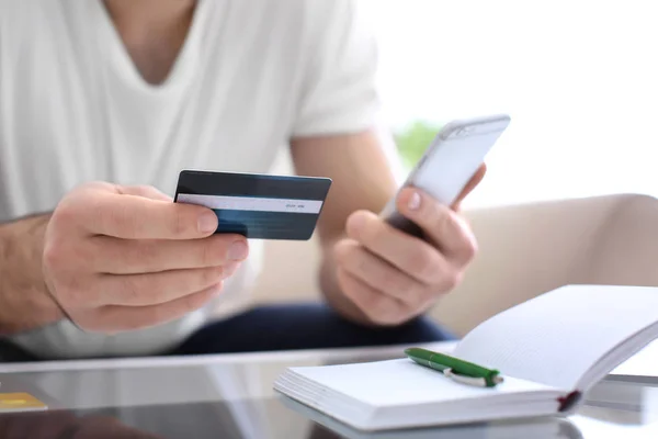 Man with credit card and mobile phone, closeup — Stock Photo, Image
