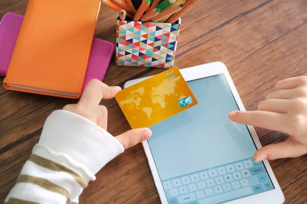 Mulher com cartão de crédito e tablet computador à mesa, close-up. Conceito de compras na Internet — Fotografia de Stock