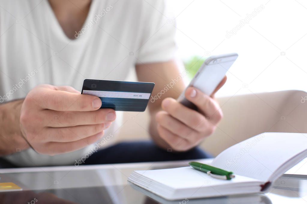 Man with credit card and mobile phone, closeup