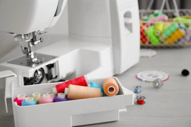 Masadaki renk iplikleri ve dikiş makinesi