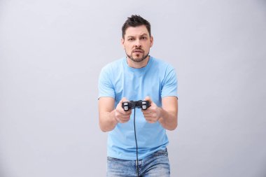 Video oyun denetleyicisi gri arka plan üzerinde olan duygusal adam