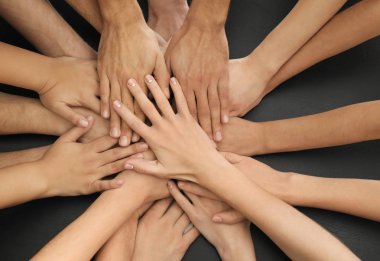 Bir grup insan birlik sembolü olarak birlikte ellerini koyarak