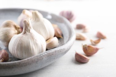 Plaka ile masa üstünde taze sarımsak