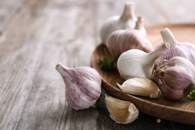 Ahşap masa üstünde taze sarımsak ile plaka