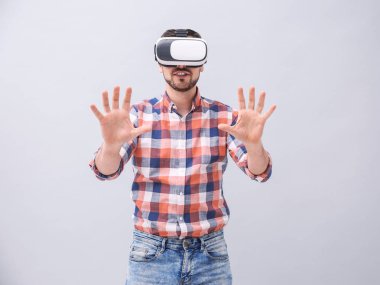 Sanal gerçeklik kulaklık gri arka plan üzerinde olan adam