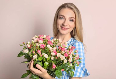 Renkli arka planda gül buketi olan güzel bir kadın.