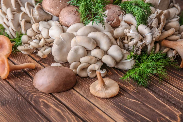 Variety of raw mushrooms on wooden table — Stock Photo, Image