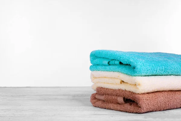 Pilha de toalhas frescas na mesa de madeira contra fundo branco — Fotografia de Stock