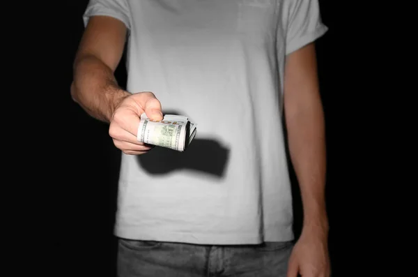 Man holding bribe on black background — Stock Photo, Image