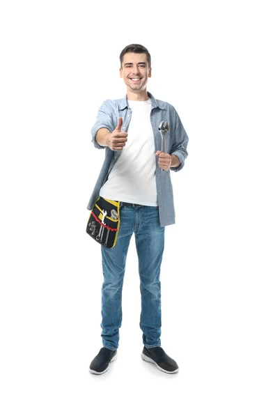 Ung rörmokare med verktygsbälte och skiftnyckel på vit bakgrund — Stockfoto