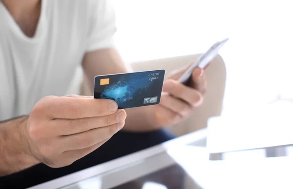 Человек с кредитной картой и мобильным телефоном, крупным планом — стоковое фото