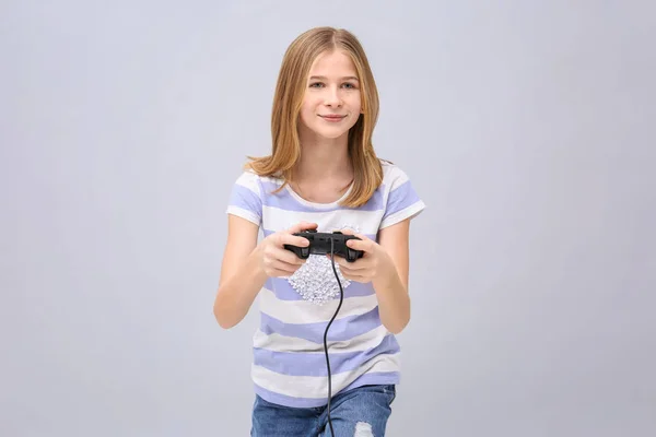 Teenager-Mädchen mit Videospiel-Controller auf grauem Hintergrund — Stockfoto