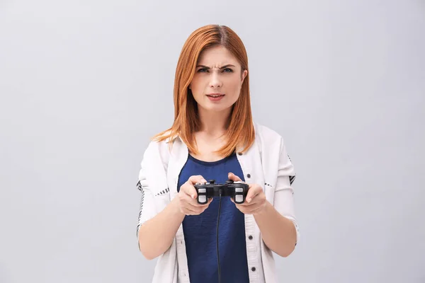 Mulher emocional com controlador de vídeo game em fundo cinza — Fotografia de Stock
