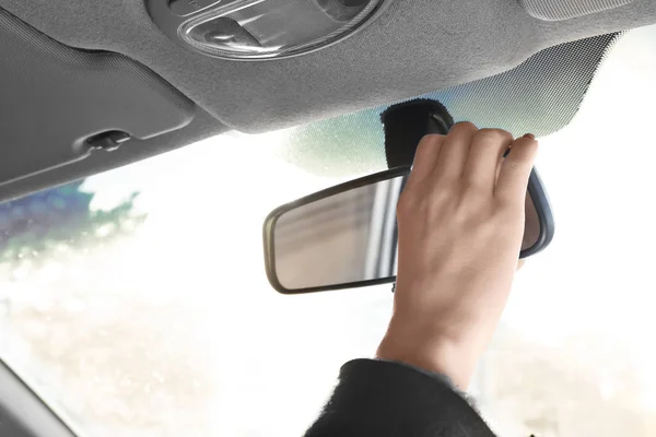 Жінка регулює дзеркало заднього виду в машині — стокове фото