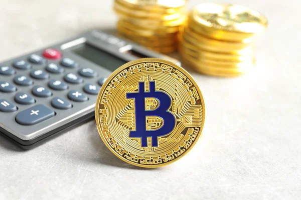 Goldener Bitcoin mit Taschenrechner auf hellem Hintergrund — Stockfoto