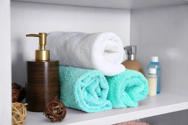 Комплект свежих полотенец и туалетных принадлежностей на полке — стоковое фото