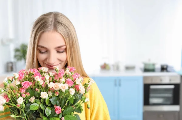 Belle jeune femme avec bouquet de roses à la maison — Photo