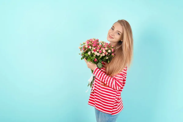 Piękna młoda kobieta z bukietem róż na tle koloru — Zdjęcie stockowe