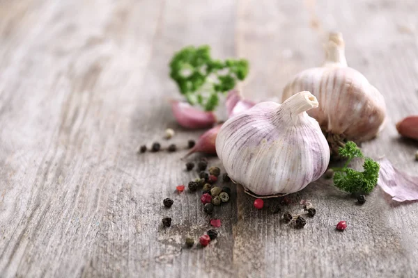 Aglio fresco con spezie su fondo di legno — Foto Stock