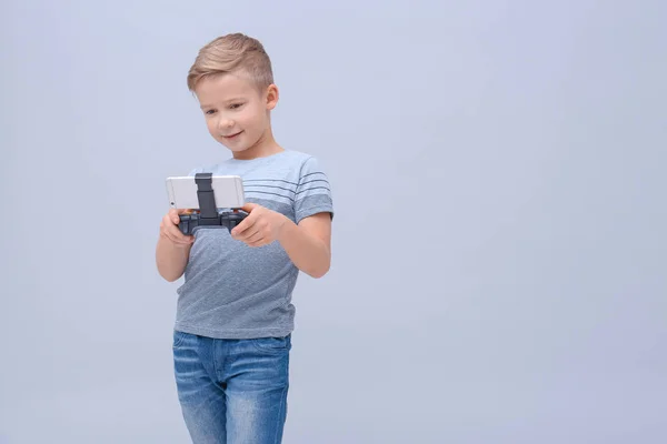 Ładny chłopak z kontrolerem gier wideo dla smartphone na kolor tła — Zdjęcie stockowe