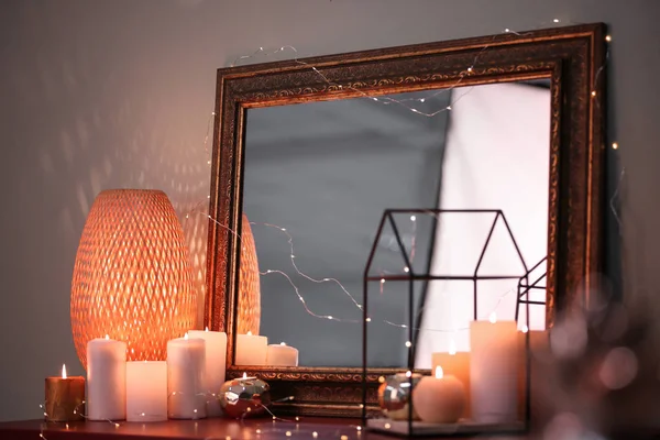Velas ardientes y hermoso espejo en la mesa — Foto de Stock