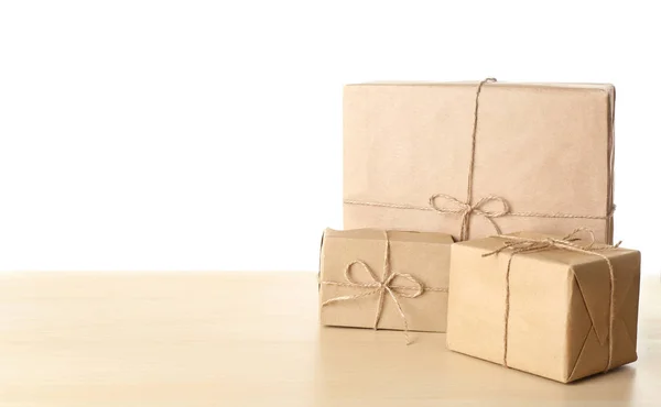 Paket-Geschenkboxen auf dem Tisch vor weißem Hintergrund — Stockfoto