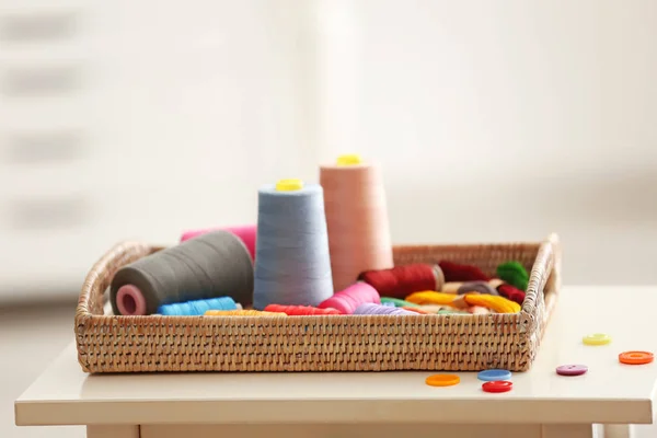 室内のテーブルの上のミシン糸と枝編み細工品トレイ — ストック写真