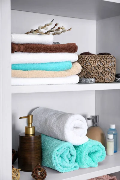 Conjunto de toalhas e produtos de higiene na prateleira — Fotografia de Stock