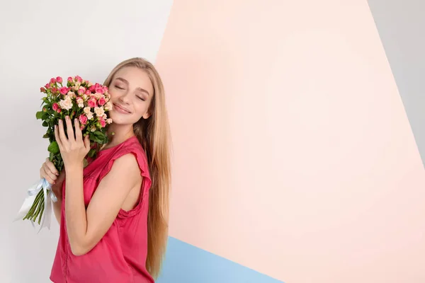 Mulher bonita com buquê de rosas no fundo de cor — Fotografia de Stock