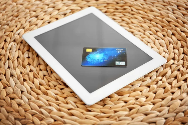 Tablet ordenador y tarjeta de crédito sobre fondo de mimbre. Concepto de compras por Internet —  Fotos de Stock