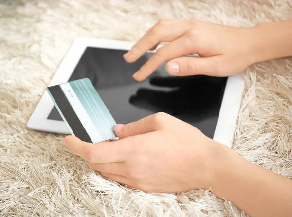 Mulher segurando cartão de crédito ao usar computador tablet em casa, close-up. Conceito de compras na Internet — Fotografia de Stock