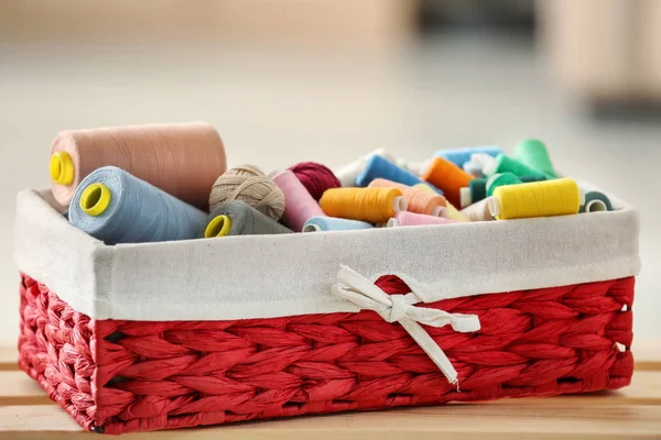 Rieten doos met kleur garens en haken clews op tafel — Stockfoto