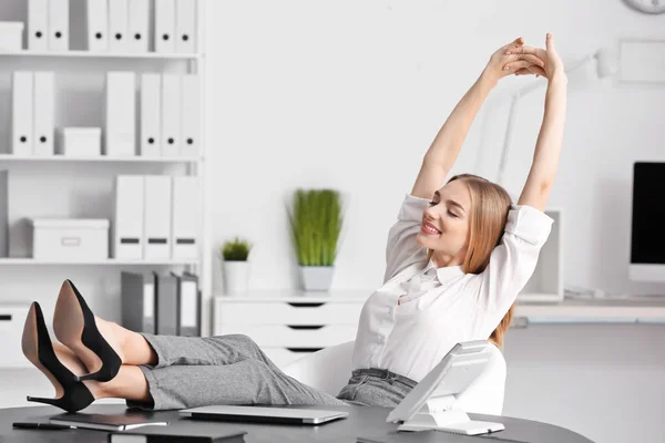 Jovem empresária relaxante no escritório — Fotografia de Stock