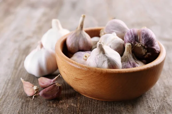 Skål med färsk vitlök på träbord — Stockfoto