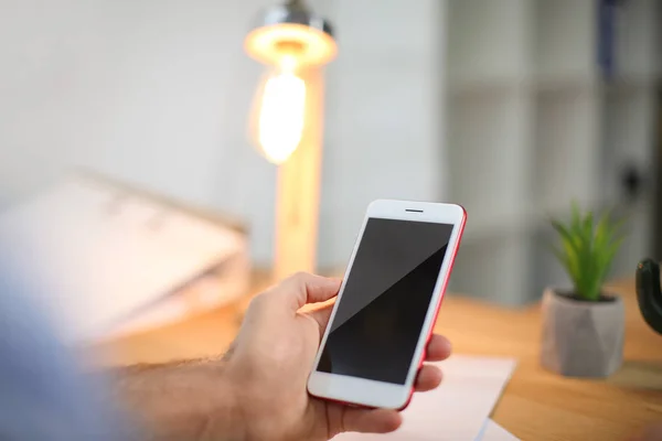 Man använder mobiltelefon inomhus, närbild — Stockfoto