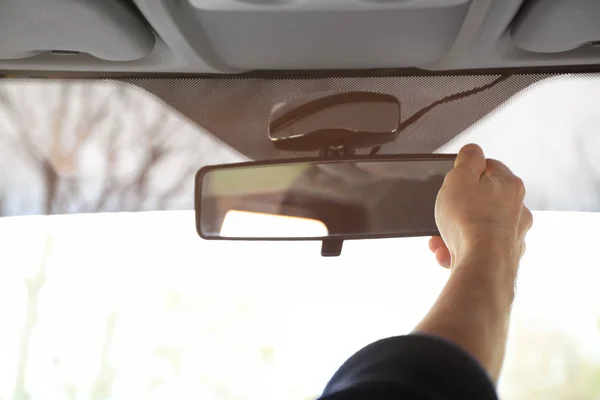 Hombre ajustando el espejo retrovisor en el coche — Foto de Stock