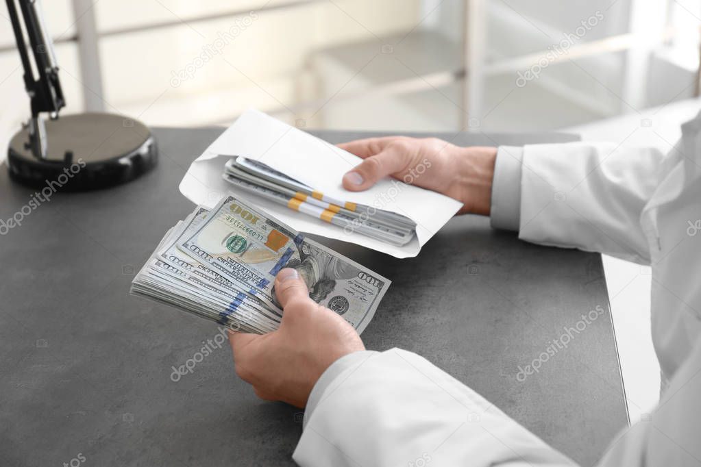 Doctor with bribe at workplace