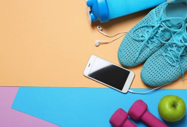 Spor malzeme, cep telefonu ve renk arka plan üzerinde egzersiz planı için boş alan. Düz yatıyordu kompozisyon