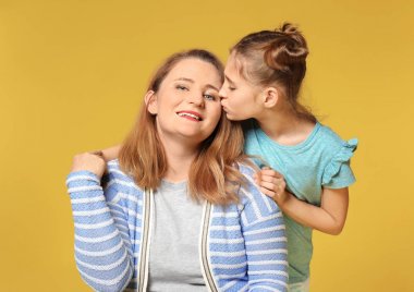 Sevimli küçük kız annesi renk arka plan üzerinde öpüşme