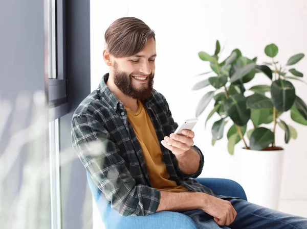 Портрет красивого мужчины с телефоном в помещении — стоковое фото