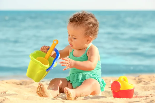 Μικρό κορίτσι παίζει με τα παιχνίδια άμμου στην παραλία — Φωτογραφία Αρχείου