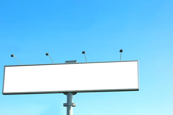 Placa de publicidade em branco ao ar livre contra o céu azul — Fotografia de Stock