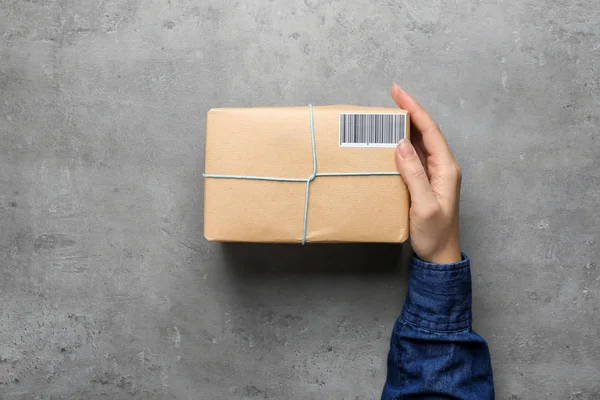 Жінка з коробкою посилок на сірому фоні — стокове фото