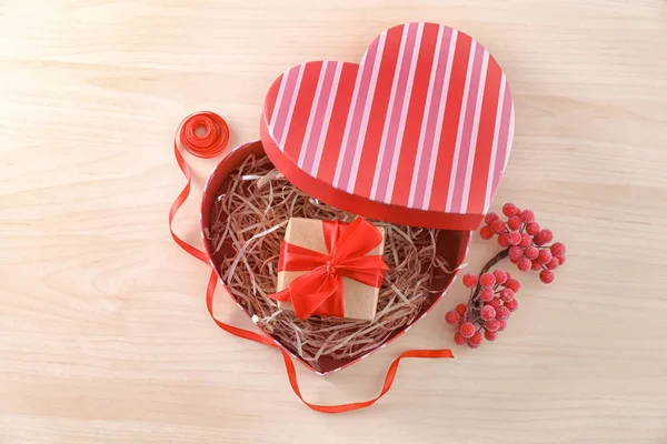 Scatola a forma di cuore con pacco regalo su tavolo di legno — Foto Stock