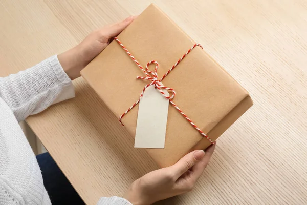 Femme avec boîte cadeau colis à table — Photo